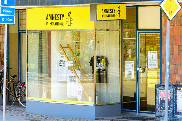 Vitrine d'un bureau Amnesty International avec des affiches et t-shirts militants"
