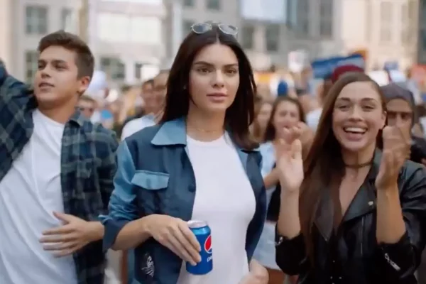 Kendall Jenner dans la pub pour Pepsi qui tient une cannette au milieu d'une foule