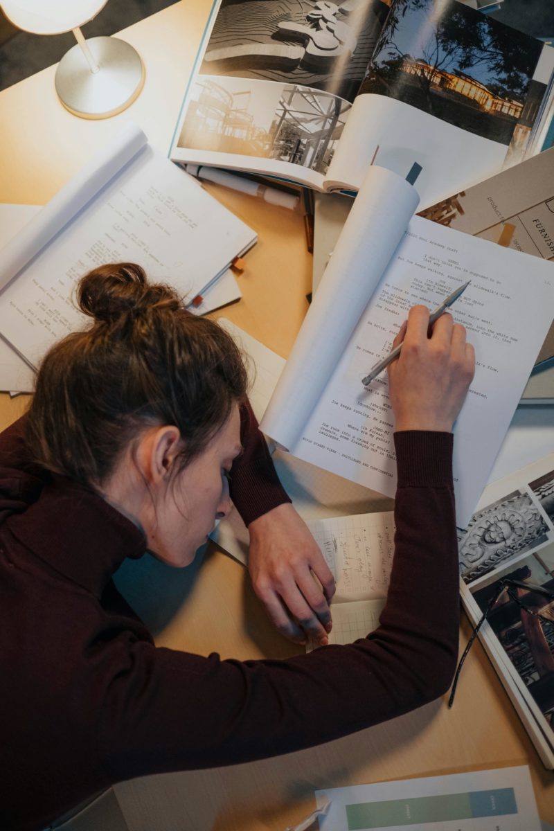 Étudiante fatiguée posant sa tête sur ses cours pendant le blocus, entourée de ses cours