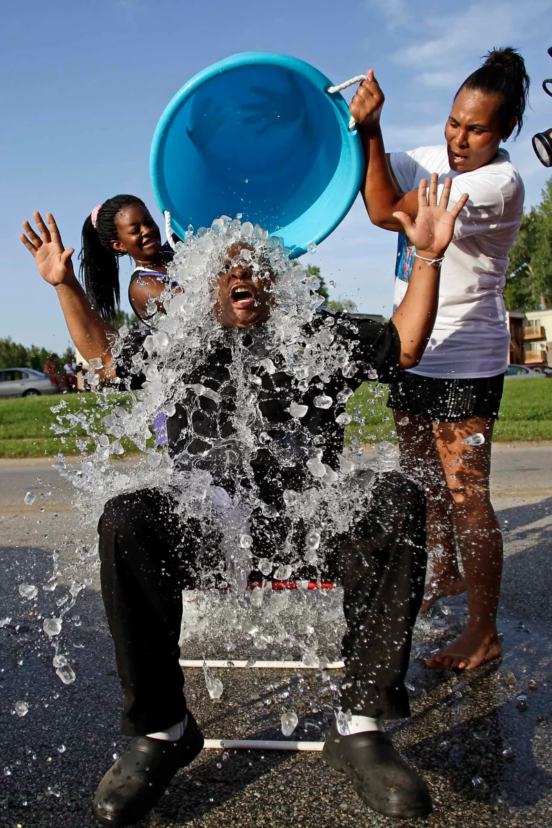 Participant du Ice Bucket Challenge recevant un seau d'eau glacée sur la tête