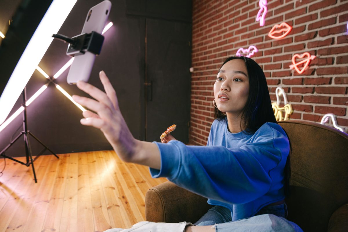 alt="Influenceuse utilisant un trépied et un smartphone pour créer du contenu digital"